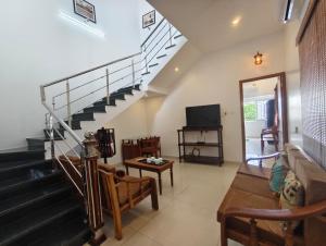 a living room with a staircase and a television at RVS Chalet in Pondicherry