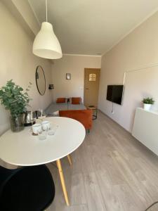 a living room with a white table and a couch at Baltic Garden Stay in Kołobrzeg