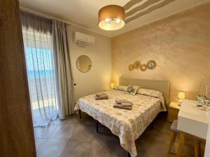 a bedroom with a bed and a large window at Castello di Sabbia in Trabia
