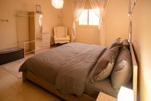 a bedroom with a bed with a chair and a window at HOMEY iNN in Medina