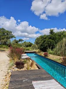 a swimming pool next to a wooden walkway at Sublim' Ecolodge in Abela