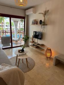 a living room with a couch and a tv and a table at El Bohemia Tenerife zuid strand rust en 3 zwembaden in Palm-Mar