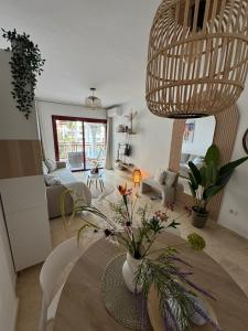 a living room with a table with flowers on it at El Bohemia Tenerife zuid strand rust en 3 zwembaden in Palm-Mar