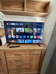 a flat screen tv sitting on top of a wooden cabinet at Modern stylish apartment in Prievidza