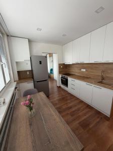 a kitchen with a wooden table with flowers on it at Modern stylish apartment in Prievidza