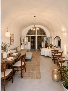 a living room with tables and chairs in a room at Lava On the Cliff in Fira