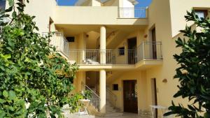 a house with a balcony and a large window at Hotel Al Paradise in San Vito lo Capo