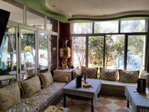 a living room with a couch and some windows at reda land in Ben Slimane