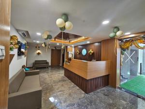 a lobby with a waiting area with green balloons at hotel vistara luxe in Himatnagar
