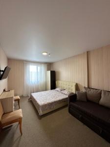 a bedroom with a bed and a couch at Villa Bossa in Zatoka
