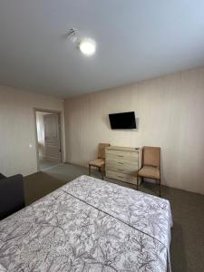 a bedroom with a bed and a dresser and a television at Villa Bossa in Zatoka