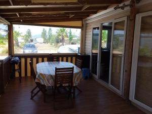 a screened in porch with a table and chairs at Mobil-home DURIS in Hyères