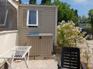 a shed with a table and a chair in front of it at Mobil-home DURIS in Hyères