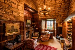 a living room filled with furniture and a stone wall at Askham Hall in Askham