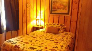 a bedroom with a bed with a blanket with animals on it at Alpine Motel in Branch Township