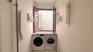 a washing machine in a laundry room with a window at Albergue Mayor in Sarria