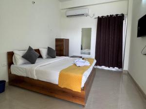 a bedroom with a large bed and a window at Hotel Galaxy Inn in Greater Noida +1 photo