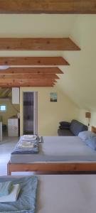 two beds in a room with wooden ceilings at Mirella apartman in Palić +31 photos
