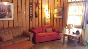 - un salon avec un canapé rouge et une chaise dans l'établissement Alpine Motel, à Branch Township
