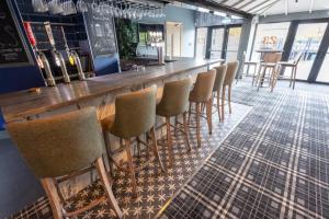 a bar with a row of stools in a room at Claremont Hotel in Alloa