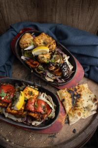 two plates of food on a wooden table with pizza at Claremont Hotel in Alloa +5 photos