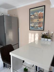 a white dining room with a white table and a refrigerator at Holiday home Dumboka in Sali