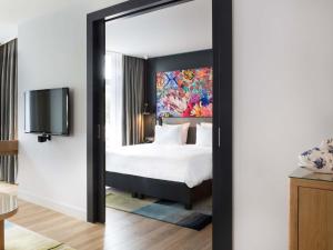 a bedroom with a bed and a mirror at Swissôtel Amsterdam in Amsterdam