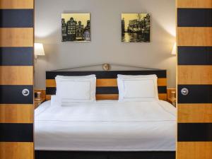 a bedroom with a white bed with two pillows at Swissôtel Amsterdam in Amsterdam