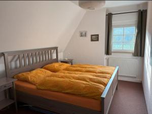 a bedroom with a bed with an orange blanket at Ferienwohnung Fluss & Fels in Stadt Wehlen