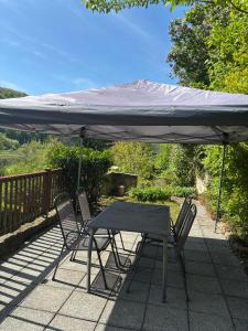 a table and chairs under an umbrella on a patio at Ferienwohnung Fluss & Fels in Stadt Wehlen