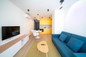 a living room with a blue couch and a table at Sun & Moon Barcelona Airport in El Prat de Llobregat
