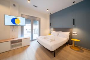 a bedroom with a bed with a tv on the wall at Sun & Moon Barcelona Airport in El Prat de Llobregat
