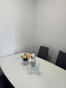 a table with a bottle of water and flowers on it at JUDITA in Omiš