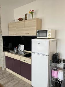 a kitchen with a microwave on top of a refrigerator at JUDITA in Omiš