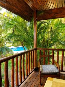 a porch with a chair and a palm tree at Hidden Home Samui in Koh Samui