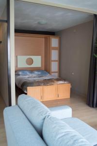 a small bedroom with a bed and a couch at Zilte bries in Nieuwpoort
