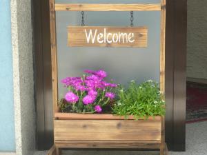 una scatola di legno con un cartello di benvenuto e fiori di Hotel Acquazzurra a Rimini