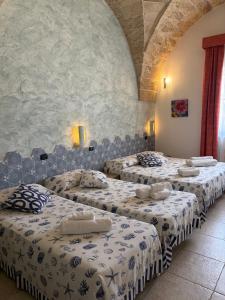 a group of four beds in a room at Villa Arneide bed and breakfast in Torre Lapillo