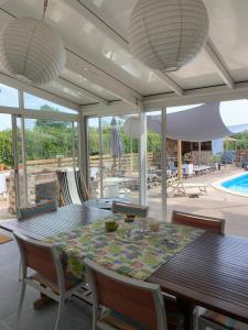 a dining room with a table and chairs and a pool at La Varenne in Changy