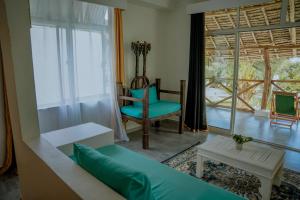 a living room with a couch and a chair and a window at Pemba Paradise in Makangale