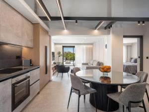 a kitchen and living room with a table and chairs at Hesperian Luxury Villas with Private Heated Pools in Chania