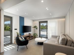 a living room with a couch and a tv at Hesperian Luxury Villas with Private Heated Pools in Chania