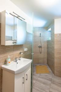 a bathroom with a sink and a shower at Vila GULBĖS TAKAS in Šventoji +40 photos