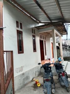 two motorcycles parked in front of a house at Kahardi guest house in Sengkol