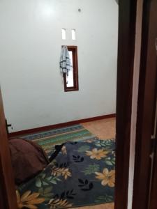 a room with a bed with a flower patterned carpet at Kahardi guest house in Sengkol