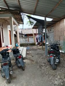 a couple of motorcycles parked under a building at Kahardi guest house in Sengkol