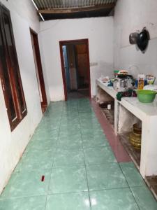 a kitchen with a green floor in a room at Kahardi guest house in Sengkol