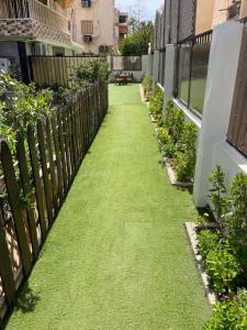 a walkway in a fence with green grass at Leila Home Garden - Maamourah Beach in Alexandria