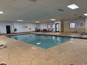 a swimming pool with blue water in a large room at Northern Lights Inn in Park Falls
