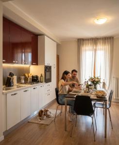a man and woman sitting at a table in a kitchen at Casa D&C in Avigliano